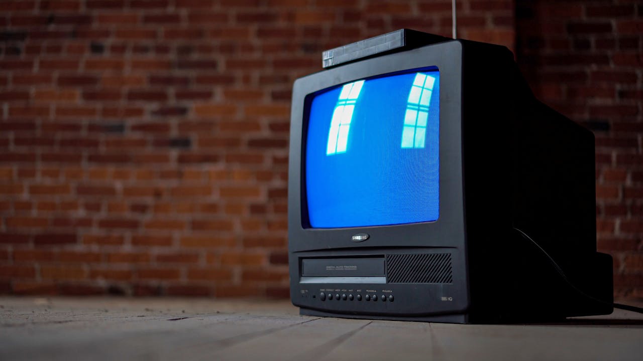 Crafting Captivating Headlines: Your awesome post title goes here Old CRT television set with a blue screen in front of a rustic brick wall, evoking nostalgia.